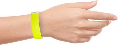 Human hand with bright yellow paper wirstband.